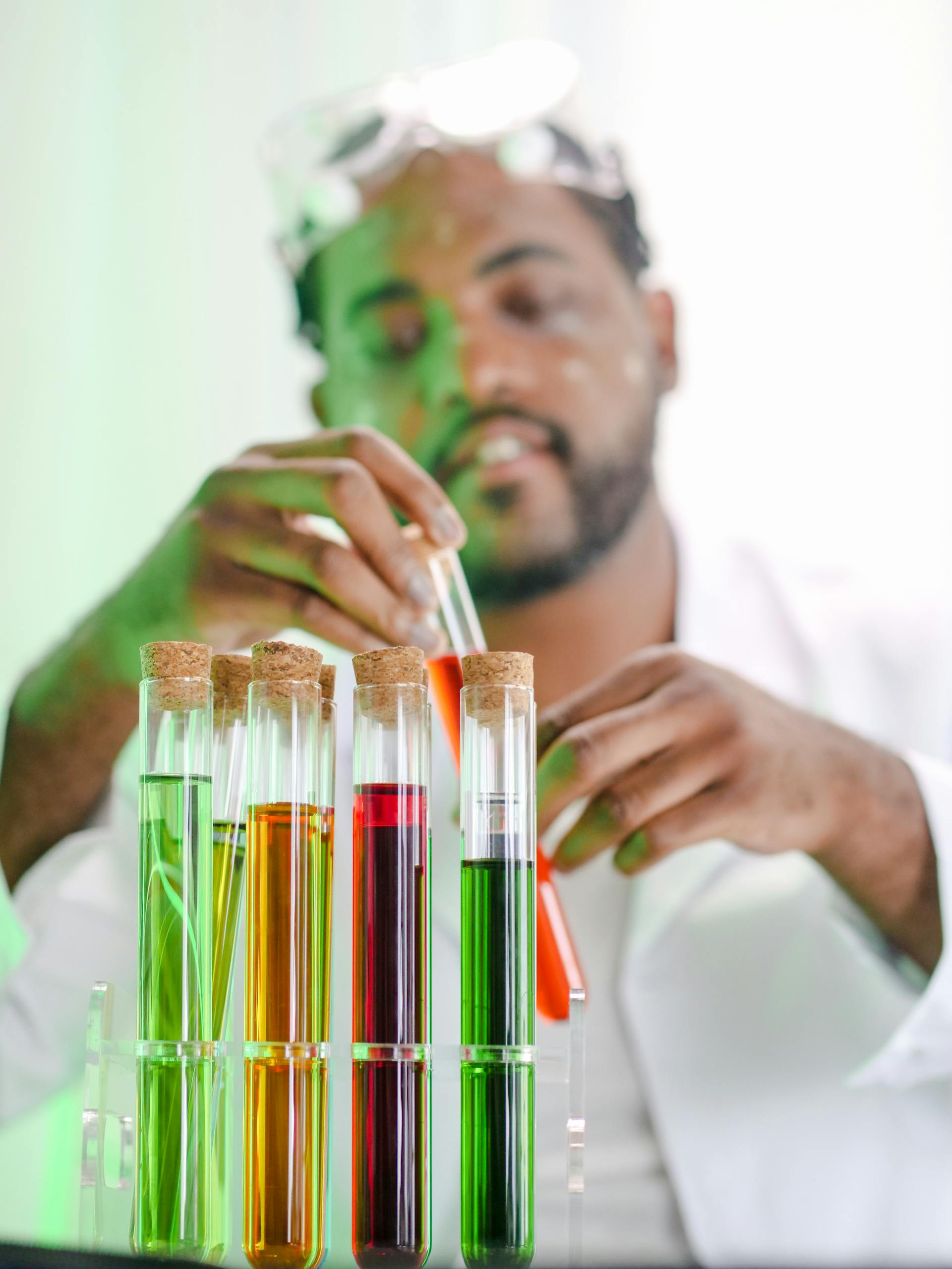 A scientist examines colorful liquids in test tubes, focusing on biochemistry research.