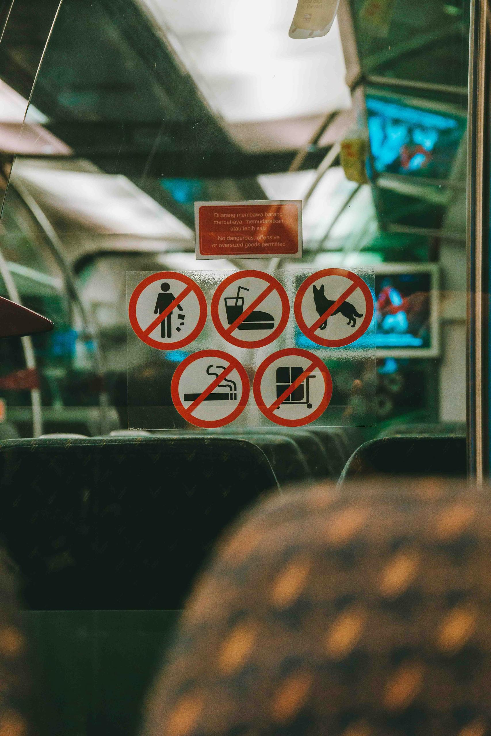 Signs indicating prohibited activities on public transportation in Kuala Lumpur.